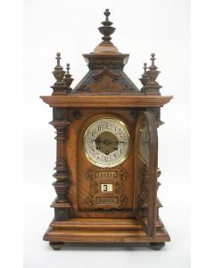 Notenhouten schoorsteenpendule met Nederlandstalige kalender, ca. 1900